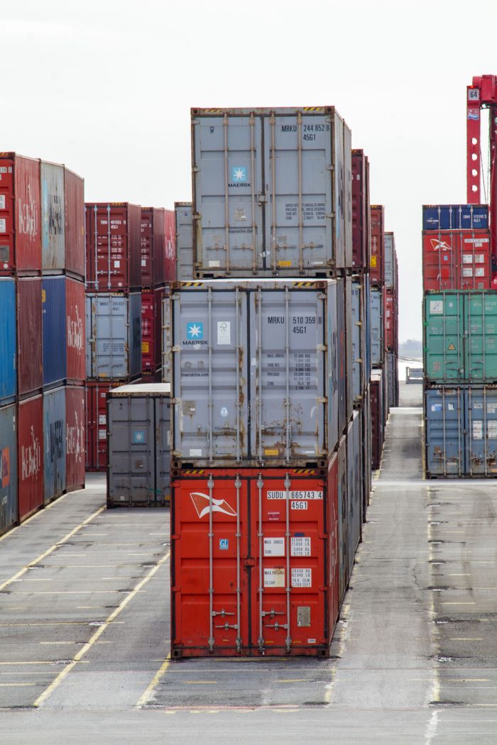 The Art of Drawing Readers In: Your attractive post title goes here Vertical shot of colorful shipping containers stacked at an industrial port, showcasing logistics.